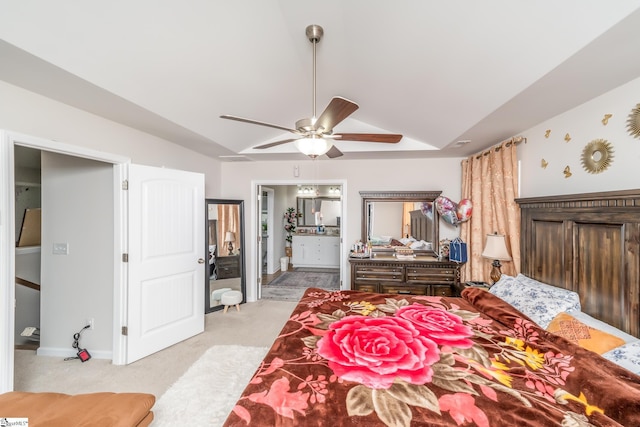 bedroom with ceiling fan, ensuite bathroom, light colored carpet, and lofted ceiling