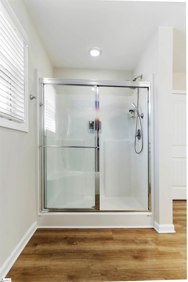 bathroom featuring hardwood / wood-style flooring and a shower with shower door