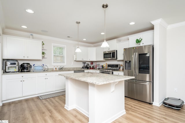 kitchen with appliances with stainless steel finishes, a kitchen island, and white cabinets