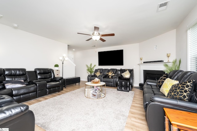 living room with light hardwood / wood-style flooring and ceiling fan