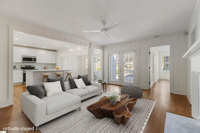 living room with french doors, light hardwood / wood-style flooring, and ceiling fan