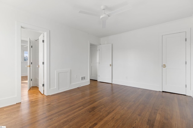 unfurnished bedroom with ceiling fan and dark wood-type flooring