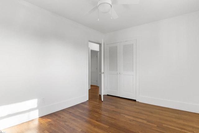 unfurnished bedroom featuring ceiling fan, dark hardwood / wood-style flooring, and a closet