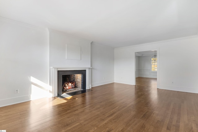 unfurnished living room featuring wood-type flooring and ornamental molding