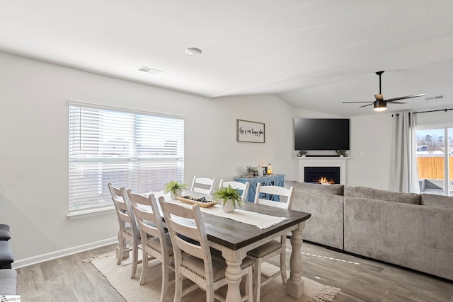 dining space featuring light hardwood / wood-style flooring, ceiling fan, and lofted ceiling