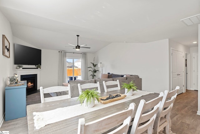 dining space featuring light hardwood / wood-style flooring, ceiling fan, and lofted ceiling