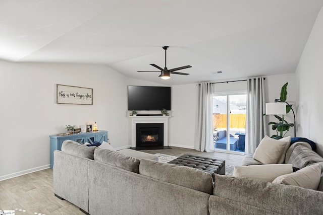 living room with ceiling fan, lofted ceiling, and light hardwood / wood-style flooring