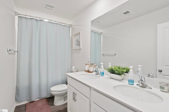 bathroom with hardwood / wood-style floors, vanity, curtained shower, and toilet