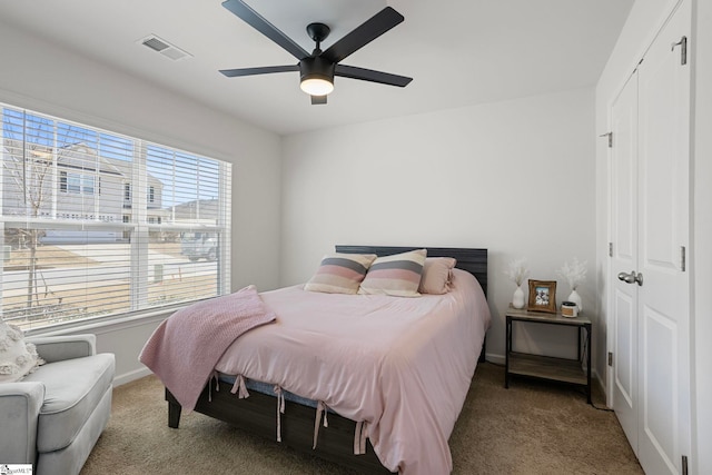 bedroom with ceiling fan, carpet floors, and a closet