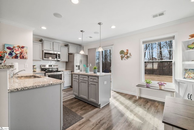 kitchen featuring gray cabinets, sink, stainless steel appliances, and decorative light fixtures