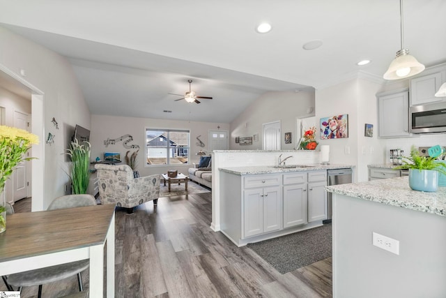 kitchen with ceiling fan, hanging light fixtures, tasteful backsplash, vaulted ceiling, and appliances with stainless steel finishes