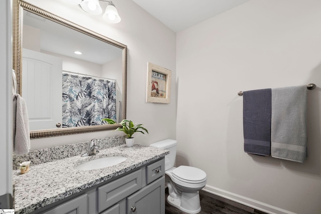 bathroom featuring vanity, hardwood / wood-style flooring, and toilet