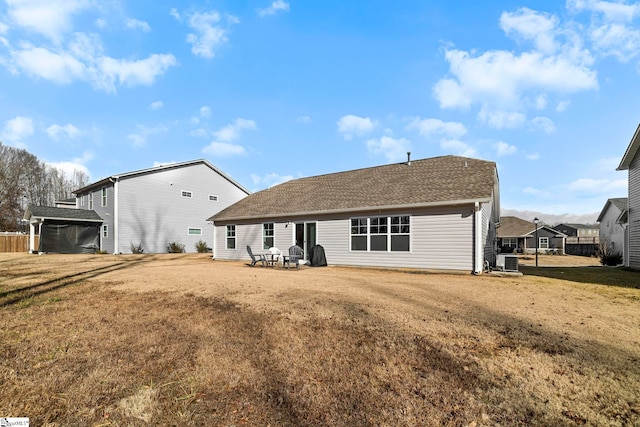 rear view of house featuring a yard and central AC