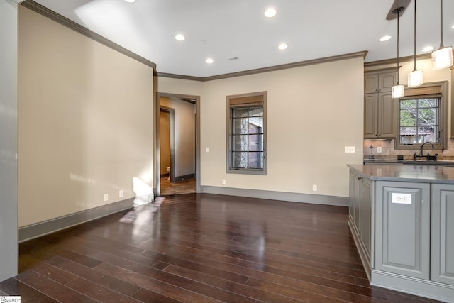 interior space featuring sink, hanging light fixtures, tasteful backsplash, dark hardwood / wood-style floors, and crown molding