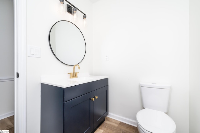 bathroom with hardwood / wood-style floors, vanity, and toilet