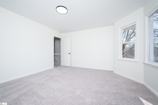 empty room with carpet floors and a wealth of natural light