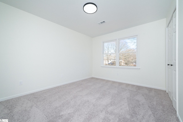 unfurnished bedroom featuring light carpet and a closet