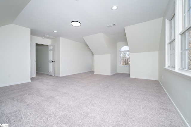 bonus room featuring light carpet and vaulted ceiling