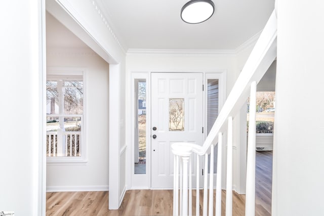 entrance foyer with light hardwood / wood-style floors and crown molding