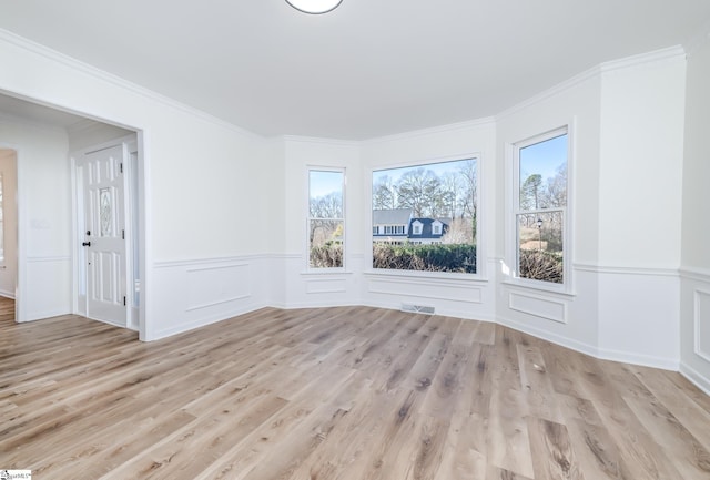 unfurnished room featuring light hardwood / wood-style floors and crown molding