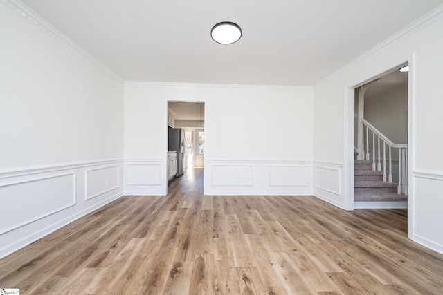 spare room featuring hardwood / wood-style flooring and ornamental molding