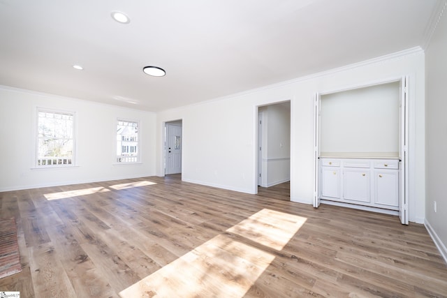 empty room with light hardwood / wood-style floors and ornamental molding