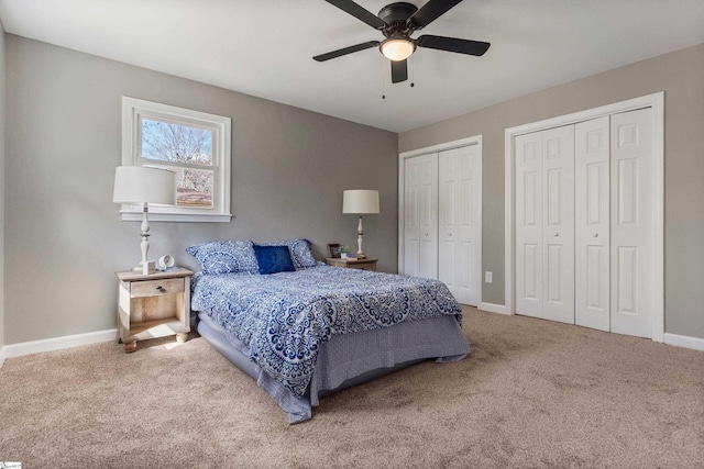 bedroom featuring carpet floors, ceiling fan, baseboards, and two closets