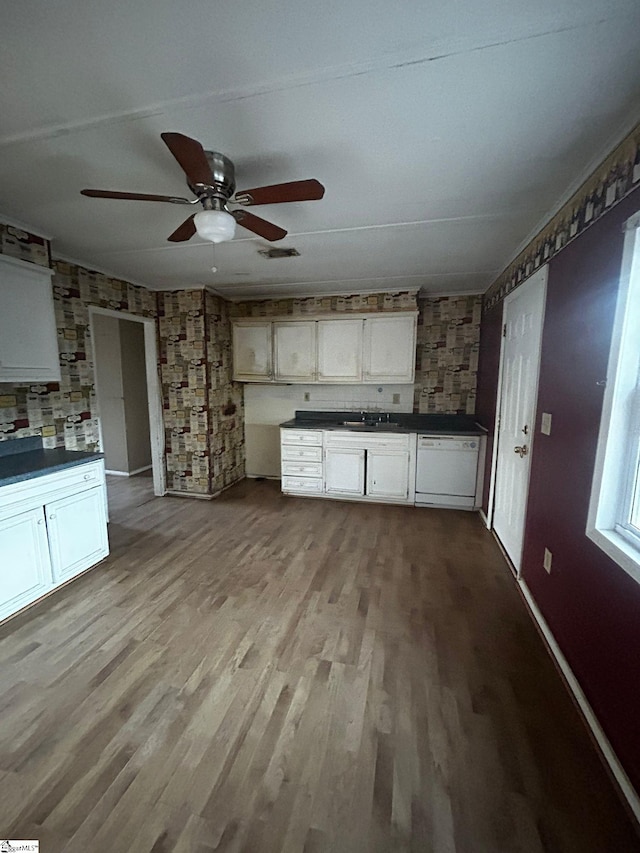 kitchen with white dishwasher, white cabinets, sink, ceiling fan, and light wood-type flooring