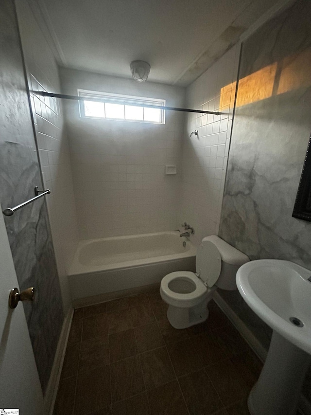 bathroom with tiled shower / bath combo and toilet