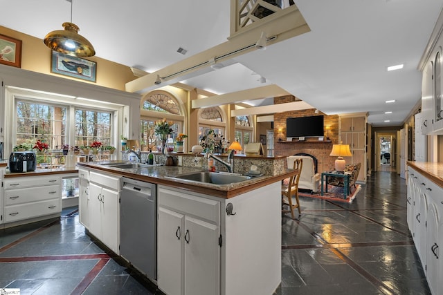 kitchen featuring dishwasher, a center island with sink, white cabinetry, and sink