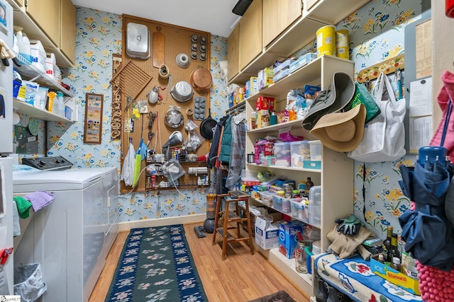 laundry area featuring cabinets, washing machine and clothes dryer, and light hardwood / wood-style flooring