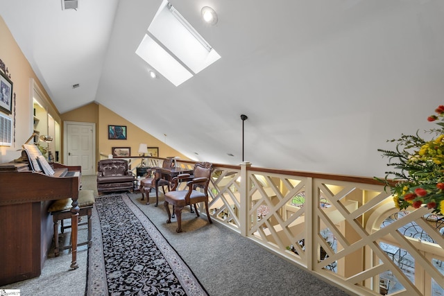 interior space featuring carpet flooring and vaulted ceiling with skylight