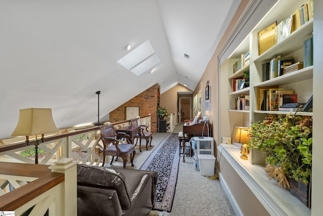 sitting room with light colored carpet, ceiling fan, and vaulted ceiling with skylight