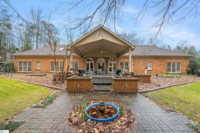 back of property featuring a patio area and a yard