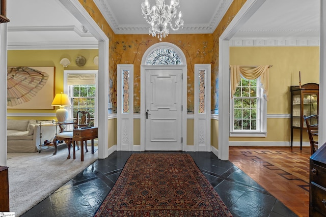 entrance foyer with crown molding and a chandelier