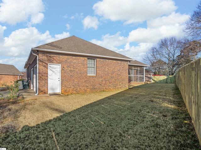 back of house with a sunroom and a yard