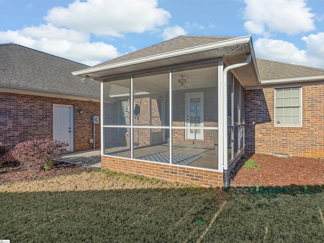 rear view of property featuring a sunroom and a lawn