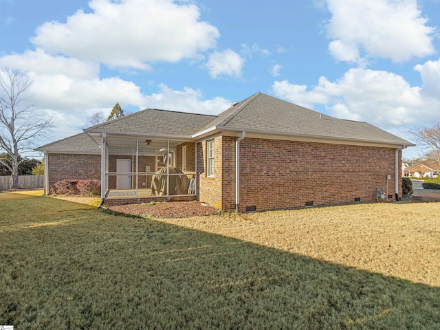 rear view of property featuring ceiling fan and a yard