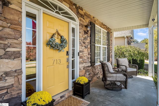 view of exterior entry featuring covered porch