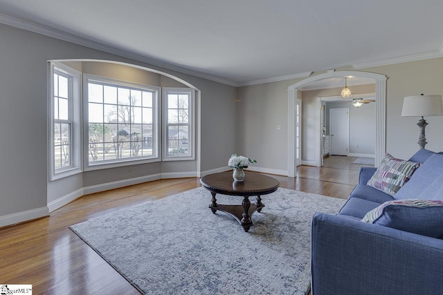 living room featuring hardwood / wood-style flooring, ceiling fan, and ornamental molding