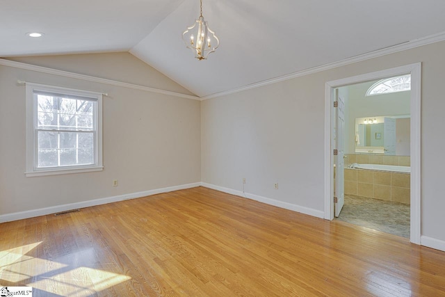 empty room featuring crown molding, light hardwood / wood-style flooring, vaulted ceiling, and a notable chandelier