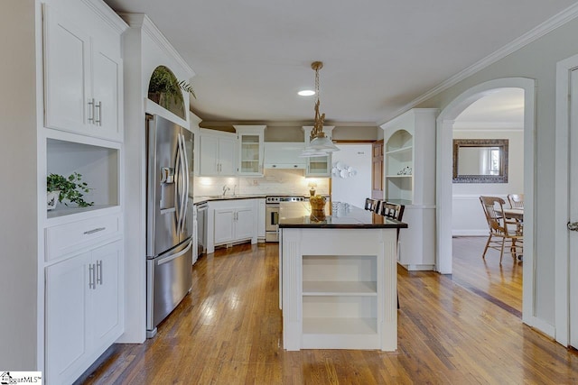 kitchen featuring pendant lighting, white cabinets, ornamental molding, a kitchen island, and stainless steel appliances