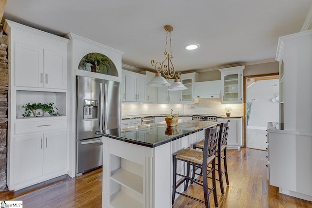 kitchen with decorative backsplash, white cabinets, stainless steel refrigerator with ice dispenser, and a kitchen island