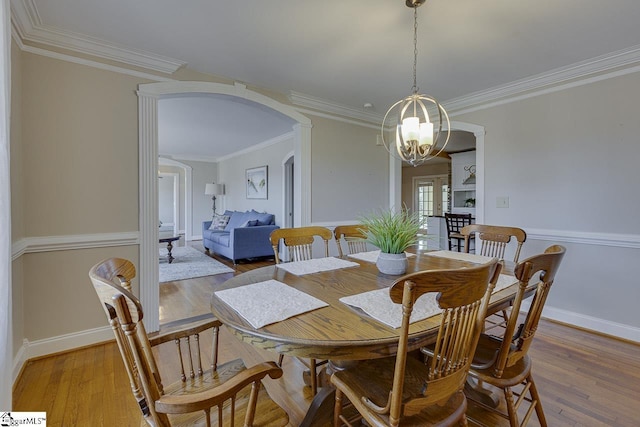 dining room featuring a notable chandelier, crown molding, and light hardwood / wood-style flooring