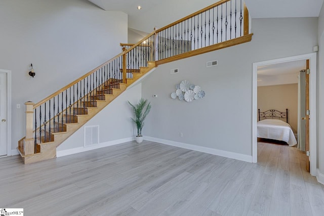 stairs featuring hardwood / wood-style floors and a towering ceiling