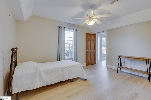 bedroom with ceiling fan, light hardwood / wood-style floors, and lofted ceiling