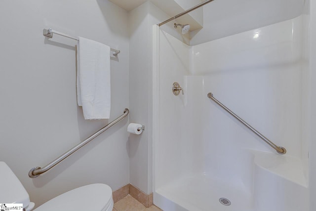 bathroom with tile patterned flooring, toilet, and walk in shower