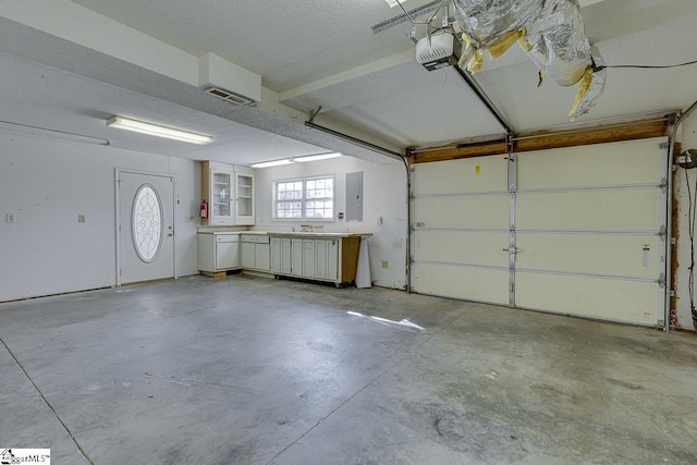 garage with electric panel and a garage door opener