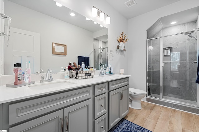 bathroom featuring vanity, toilet, and a shower with shower door