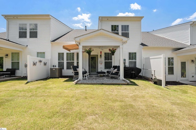 back of property with a lawn, central AC, and a patio